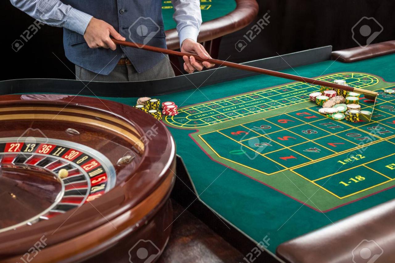Roulette And Piles Of Gambling Chips On A Green Table In Casino. Croupier Collects Chips Using Stick Stock Photo, Picture And Royalty Free Image. Image 51318926.