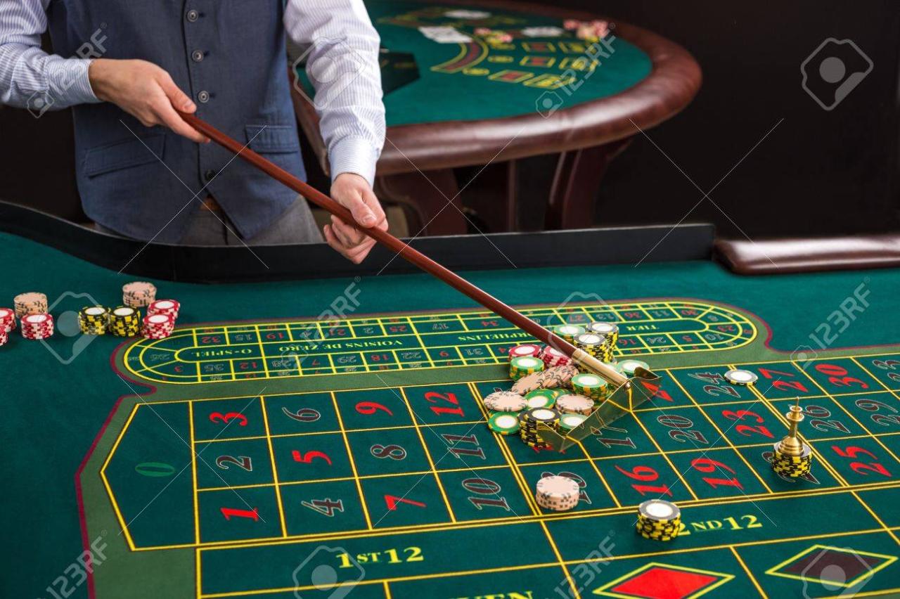 Close Up Of Gambling Chips On A Green Table In Casino. Croupier Collects Chips Using Stick Stock Photo, Picture And Royalty Free Image. Image 51318931.